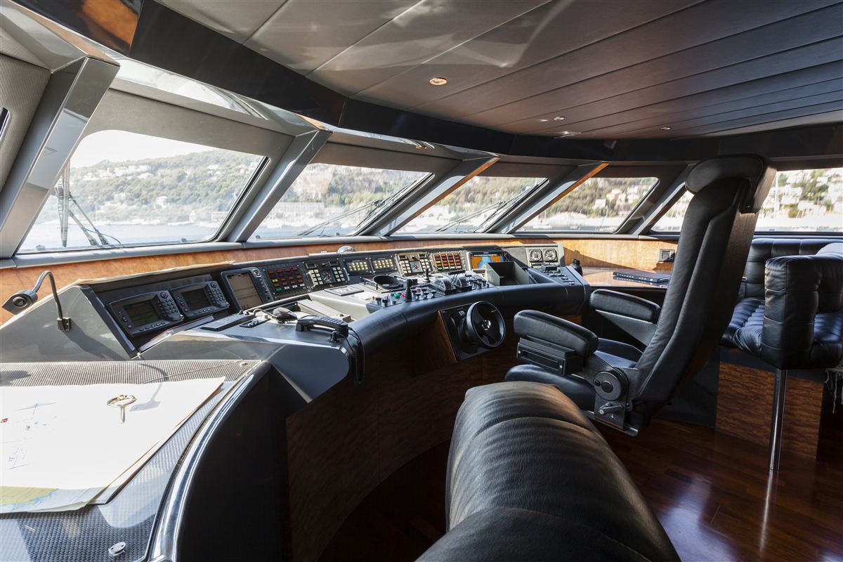 The wheelhouse of a large motor yacht, with helm seats and wide windows