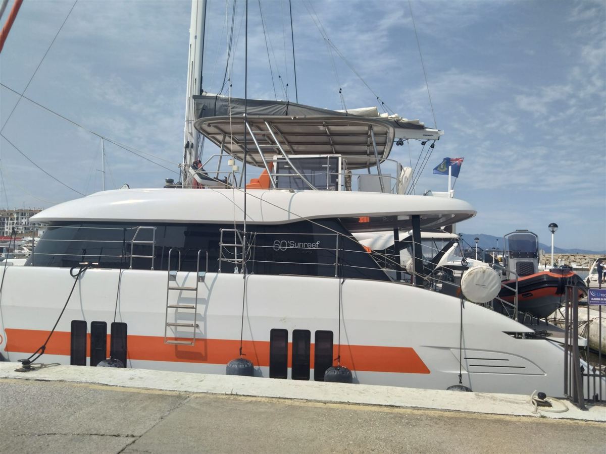 A power catamaran alongside in a marina