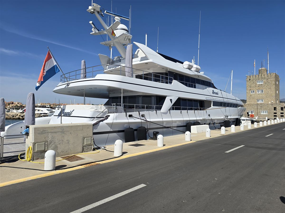 A large motor yacht moored along a harbour quay