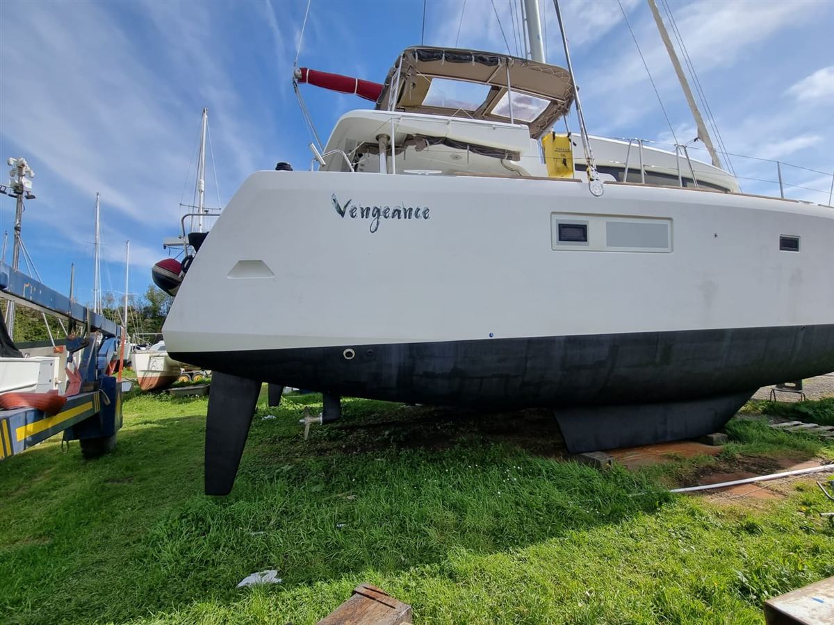 A sailing catamaran out of the water on a grass hardstand