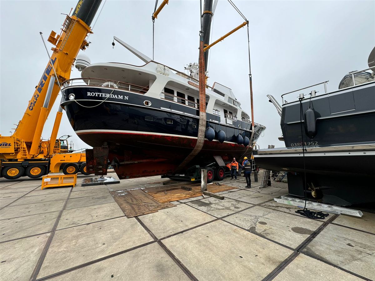 An explorer yacht lifted by crane in a port