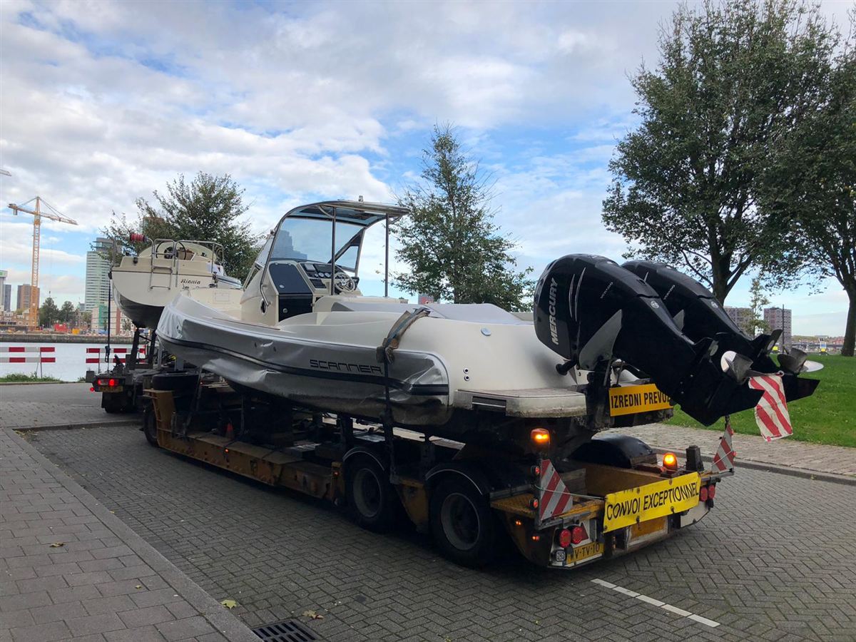 A rigid inflatable boat with outboard engines on a transport trailer